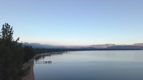 Sol-Saliendo-Sobre-El-Lago-Tahoe-En-Invierno,-Imágenes-De-Drones-Sobrevolando