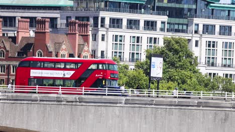 a red bus travels across a bridge