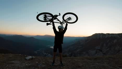 Young-man-taking-his-bike-above-his-head-as-a-symbol-of-success