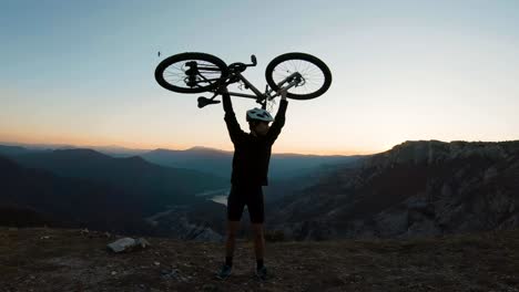 Junger-Mann,-Der-Sein-Fahrrad-Als-Symbol-Des-Erfolgs-über-Den-Kopf-Nimmt