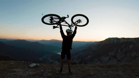 joven tomando su bicicleta por encima de su cabeza como símbolo de éxito