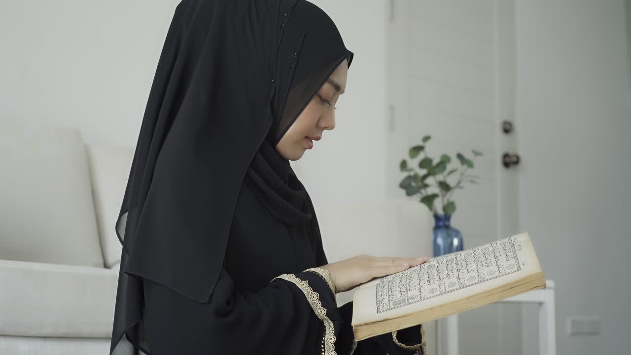 An Asian Muslim woman reciting Salah or Salat al-Fatiha passage of the Qur'an, in a single act of sujud called a sajdah or prostrations at home