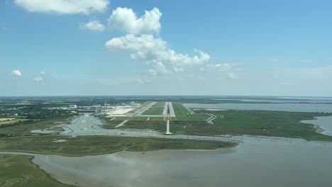 Unique-pilot’s-perspective-during-a-real-approach-to-Venice’s-airport,-Italy,-with-a-sunny-day-and-blue-sky,-with-the-runway-ahead