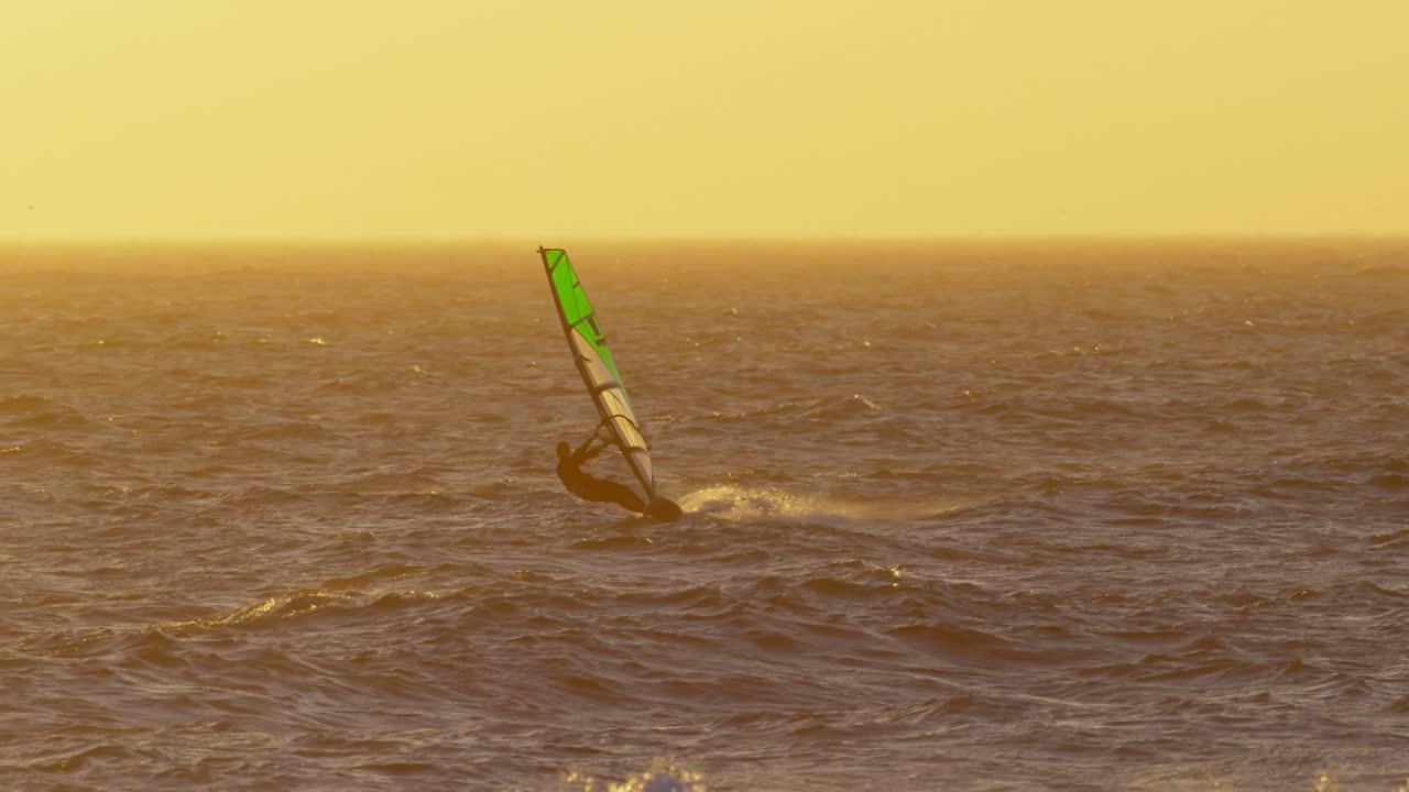 surfista masculino haciendo windsurf en la playa 4k