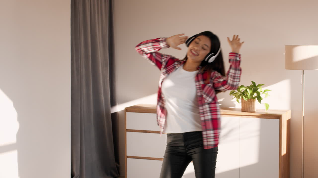 Happy Woman Dancing to Music at Home