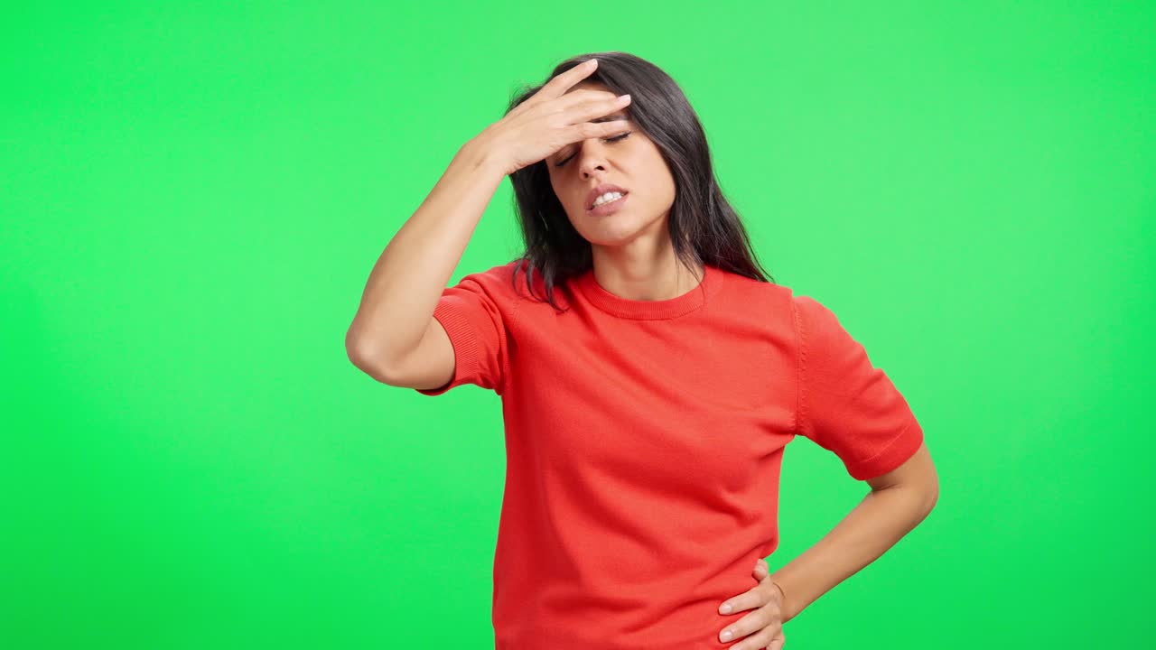 Giovane donna che soffre di mal di testa su schermo verde