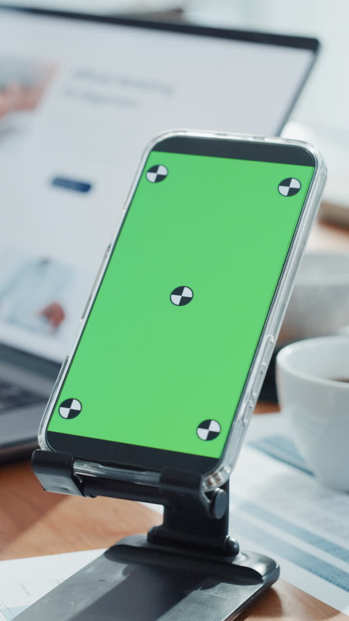 Smartphone con schermo verde su supporto in un ufficio
