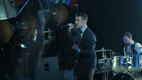 stylish group of young men musician or rock band playing on the stage in the club