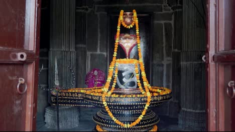 Der-Hinduistische-Religiöse-Gott-Shiva-Shivalinga-Ist-Aus-Verschiedenen-Blickwinkeln-Mit-Blumen-Geschmückt.-Das-Video-Im-Alten-Tempel-Wurde-In-Der-Kumbhal-Festung-Kumbhalgarh-In-Rajasthan,-Indien,-Aufgenommen.