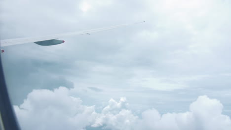 flying through the clouds on an airplane to singapore from australia