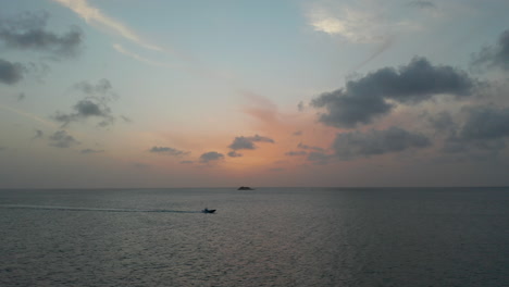 Aerial-view-luxury-speedboat-cruise-on-Antigua-and-Bermuda-coastline-on-scenic-dramatic-sunset-in-summer