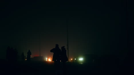 silhouette of people walking in fog at night