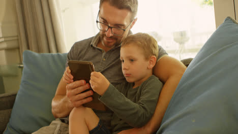 Father-and-son-using-laptop-on-sofa-4k
