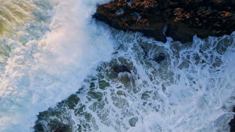 powerful ocean waves crashing coastal rocks closeup. rough sea water splashing