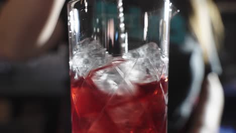 bartender stirring an icy beverage in a bar