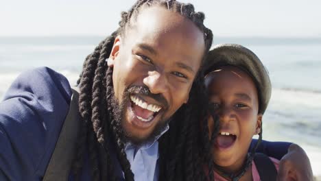 video of happy african american father and son in helmet taking selfie outdoors