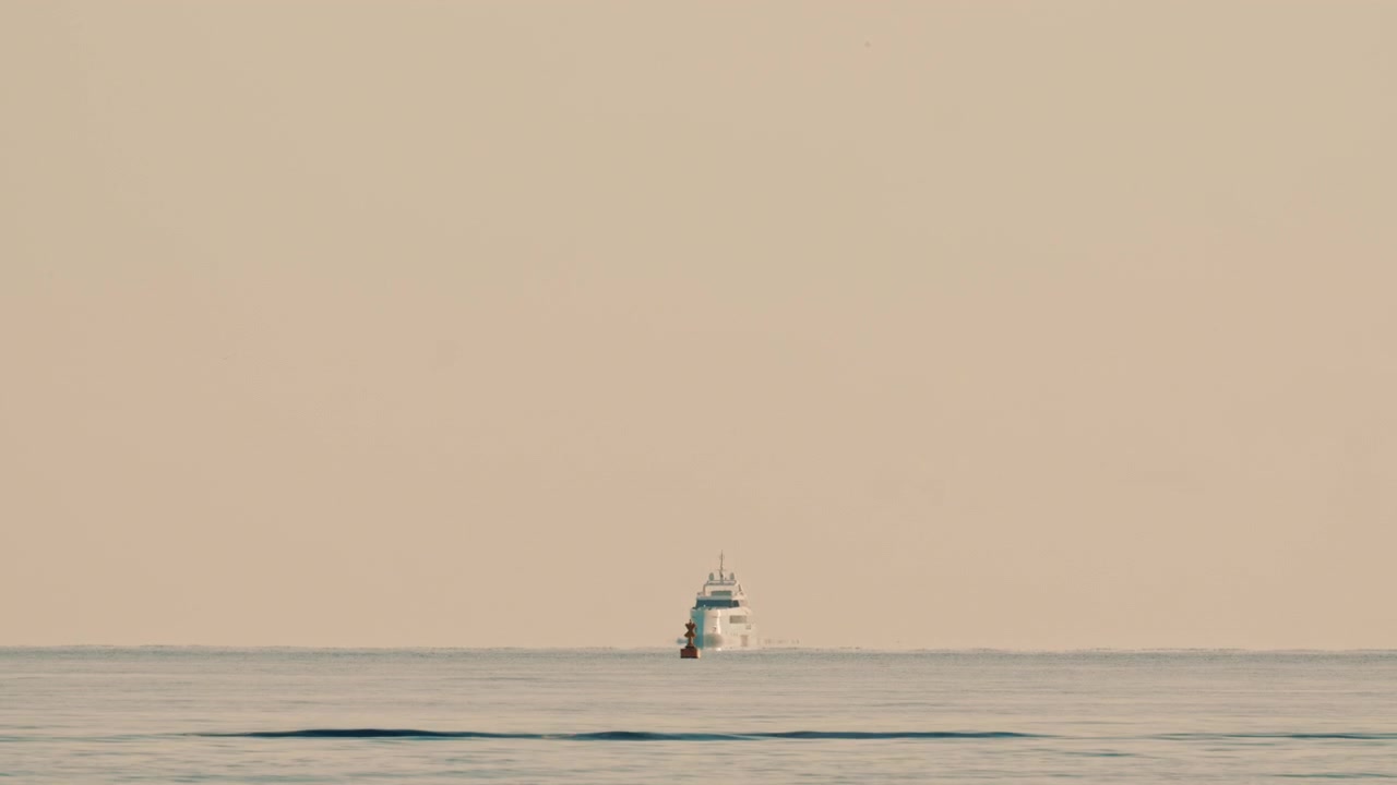 A navigation buoy in the foreground and a yacht on the horizon in the Mediterranean Sea near France