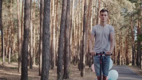 a young man rides an electric scooter through the park with balloons