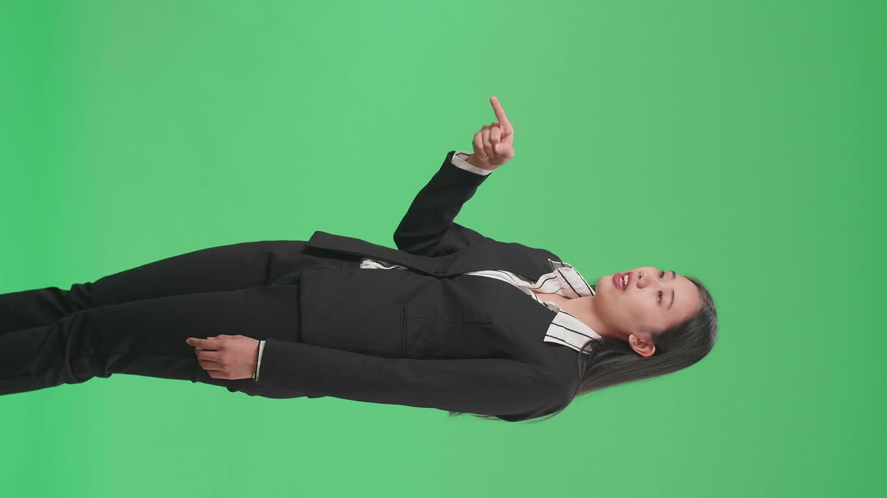 Side View Of An Angry Asian Business Woman Scolding While Standing On Green Screen In The Studio