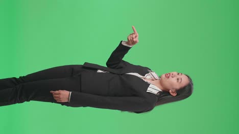 side view of an angry asian business woman scolding while standing on green screen in the studio