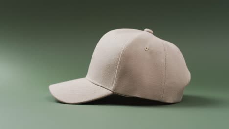 video of beige baseball cap and copy space on green background