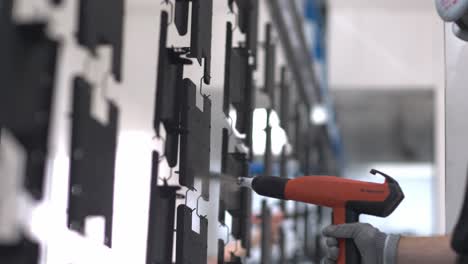 slow motion close up tracking shot of an industrial emplyee, painting a metal sheet