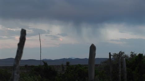 tiro largo de nubes de lluvia moviéndose sobre un paisaje rural