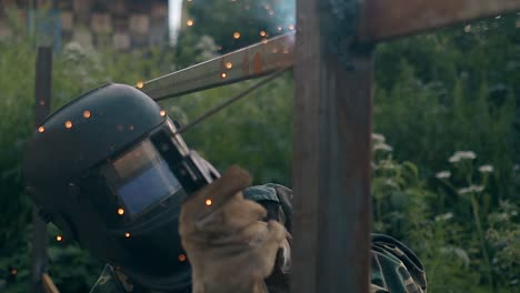 slow-motion-man-finishes-fence-welding-and-looks-at-results