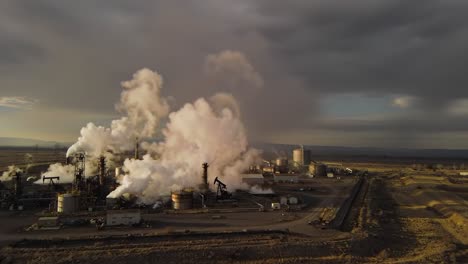 industrial complex emitting steam in an aerial view: a captivating look at machinery, energy production, and environmental impact amidst dramatic cloudy sky