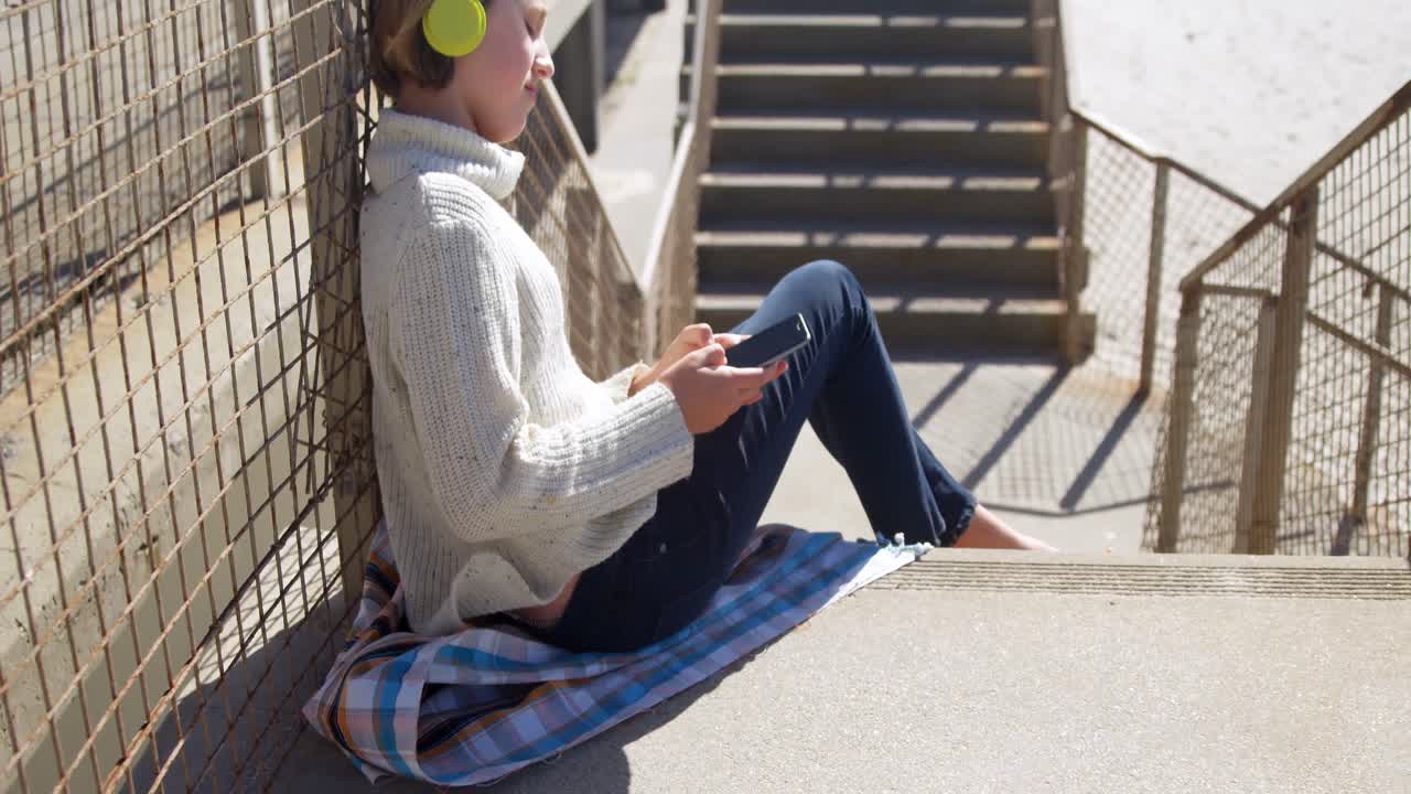 Girl using mobile phone near beach 4k