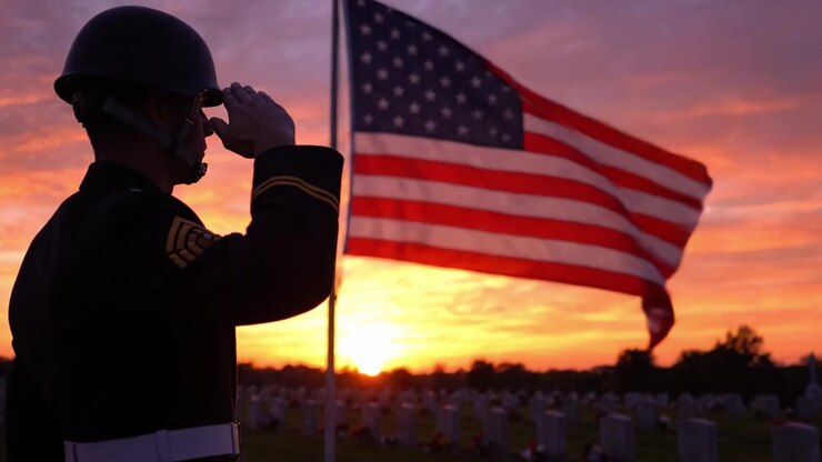 Un Solenne Tributo al Crepuscolo: Un Soldato Saluta la Bandiera Americana con Reverenza su uno Sfondo di un Bellissimo Tramonto su un Cimitero Sereno