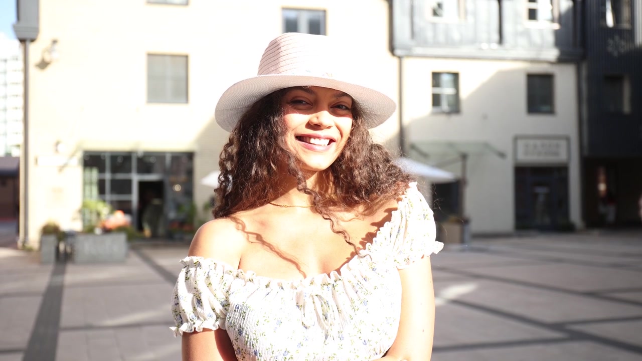 Jovem Mulher Feliz com Chapéu Sorrindo ao Ar Livre