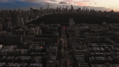 drone footage of harlem new york city sunset facing central park panning down to street