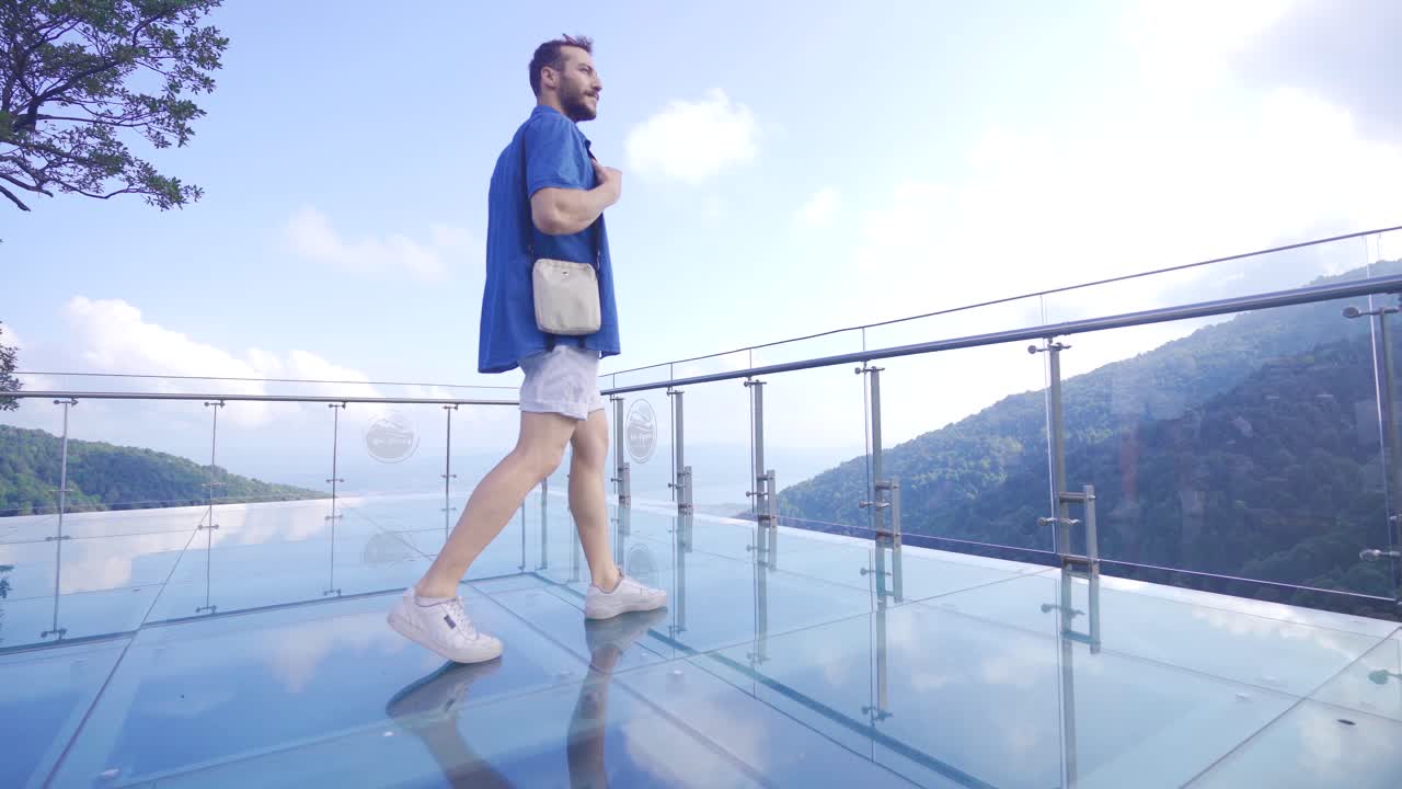 Uomo che cammina su una terrazza di vetro