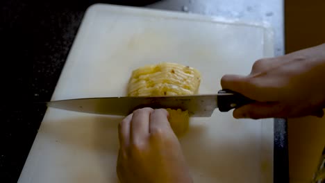 primer plano de cortar piña amarilla en una tabla para cortar
