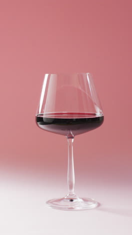 vertical video of red wine glass on marsala background