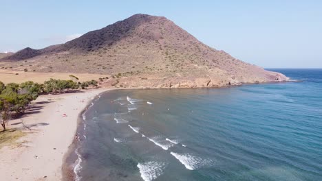 los genoveses beach at cabo de gata, almeria, andalucia, spain - aerial view of tourists at the sandy beach and vulcanic landscape