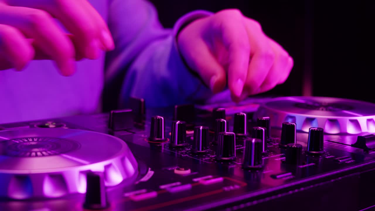 DJ with headphones and sunglasses playing music on festival in night club. Techno musician performing at nightclub for concert crowd of people, city bar.