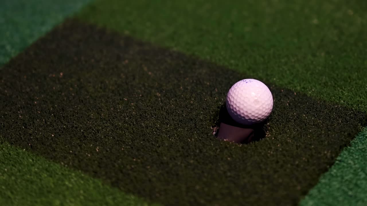 una pelota de golf moviéndose más cerca de la copa en el verde.