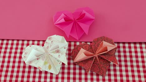 folded decorative origami paper valentine hearts, checkered tablecloth