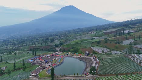 aerial scenery of water reservoir and plantation with mountain background in the morning. indonesia nature rural landscape.
