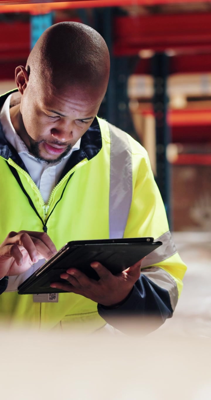 Warehouse Worker Using Digital Tablet for Inventory Management