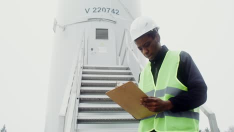 worker inspecting wind turbine facility