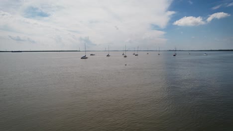 drone-flies-through-moored-sailboats-sunny-summer-day-calm-river