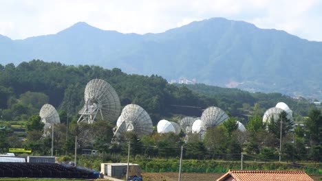 kt sat satellite dishes in kumsan over big mountains, south korea at daytime - static shot