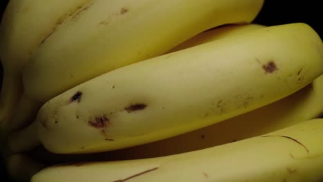 tilt down of bananas isolated on black background, closeup