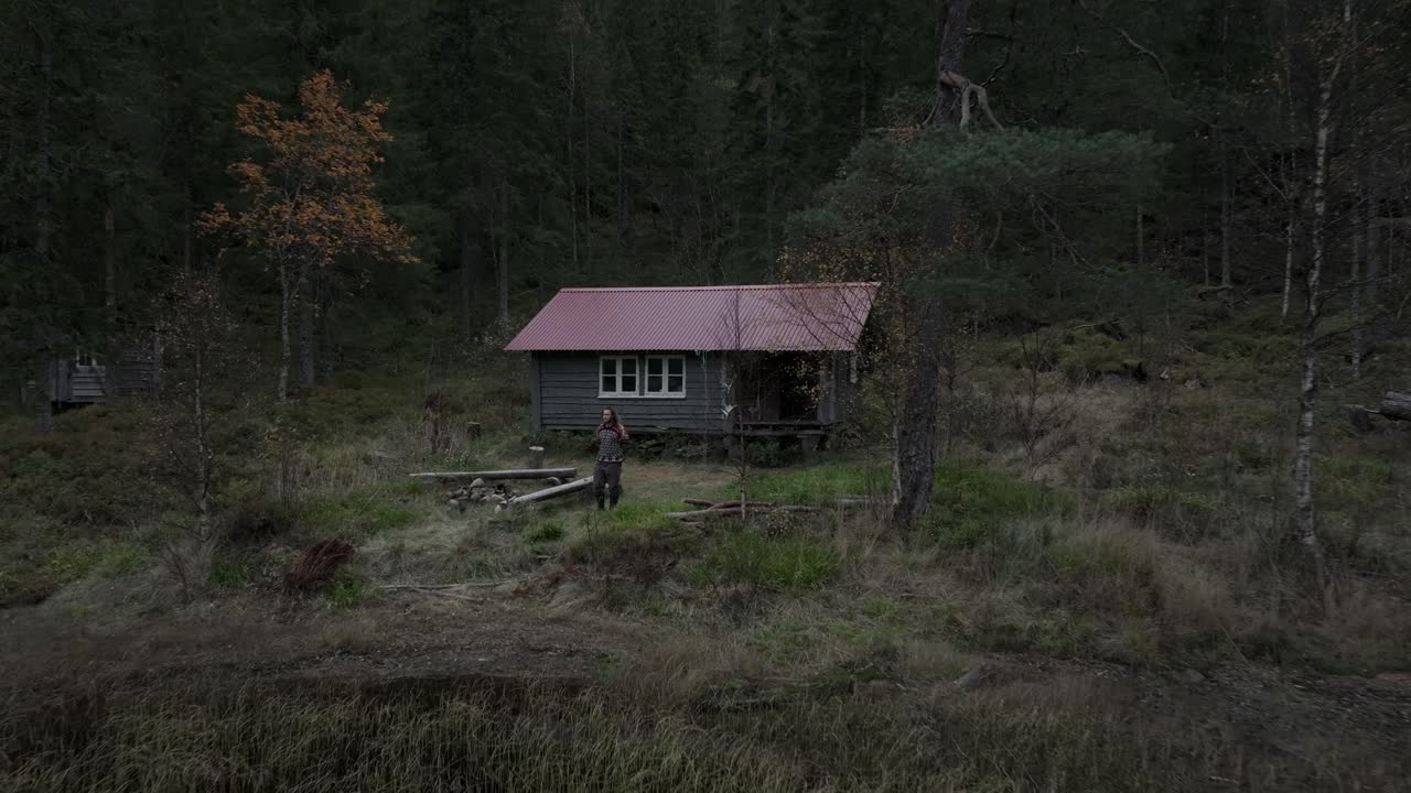 Hildremsvatnet, Trondelag County, Norway - A Gentleman Strolling Toward the Lakeshore, With a Fisherman's Cottage in the Backdrop - Aerial Pullback