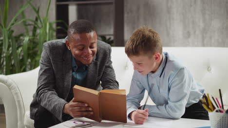 african-american man tutor laughs reading book with student