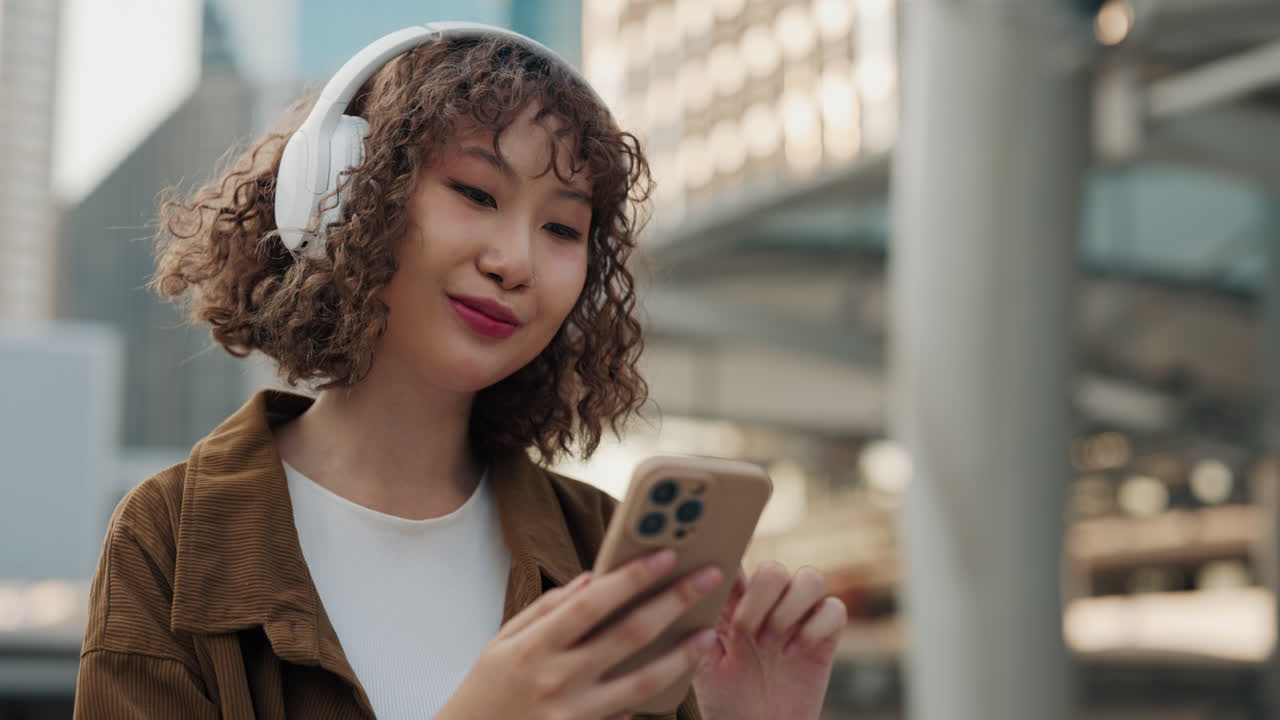 Woman Using Smartphone While Listening to Music Outside