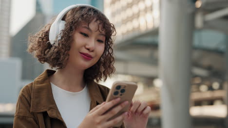 woman using smartphone while listening to music outside